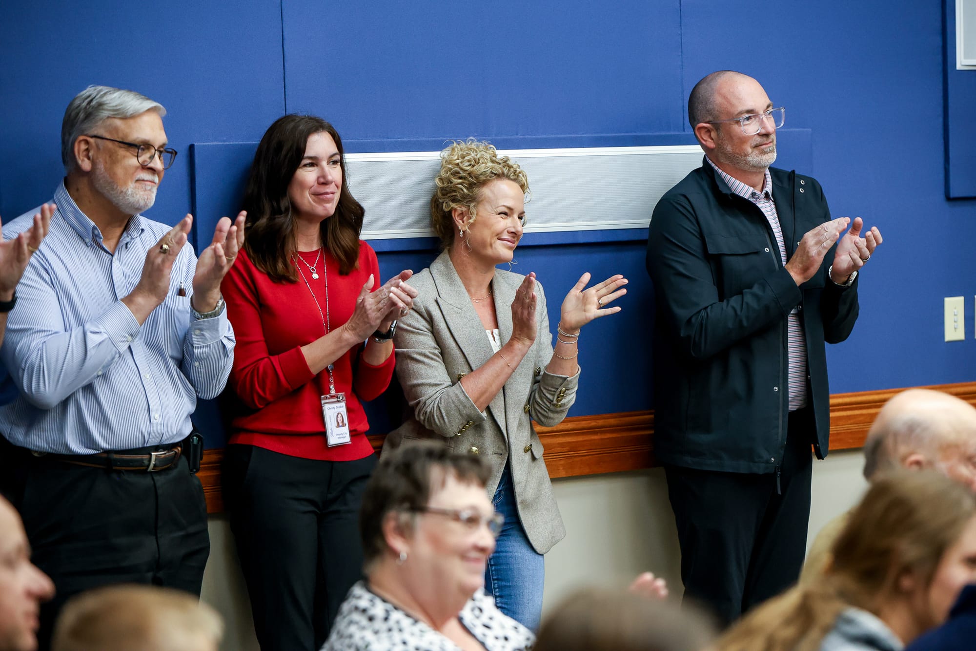 Four city officials standing and clapping at fire chief swearing-in event
