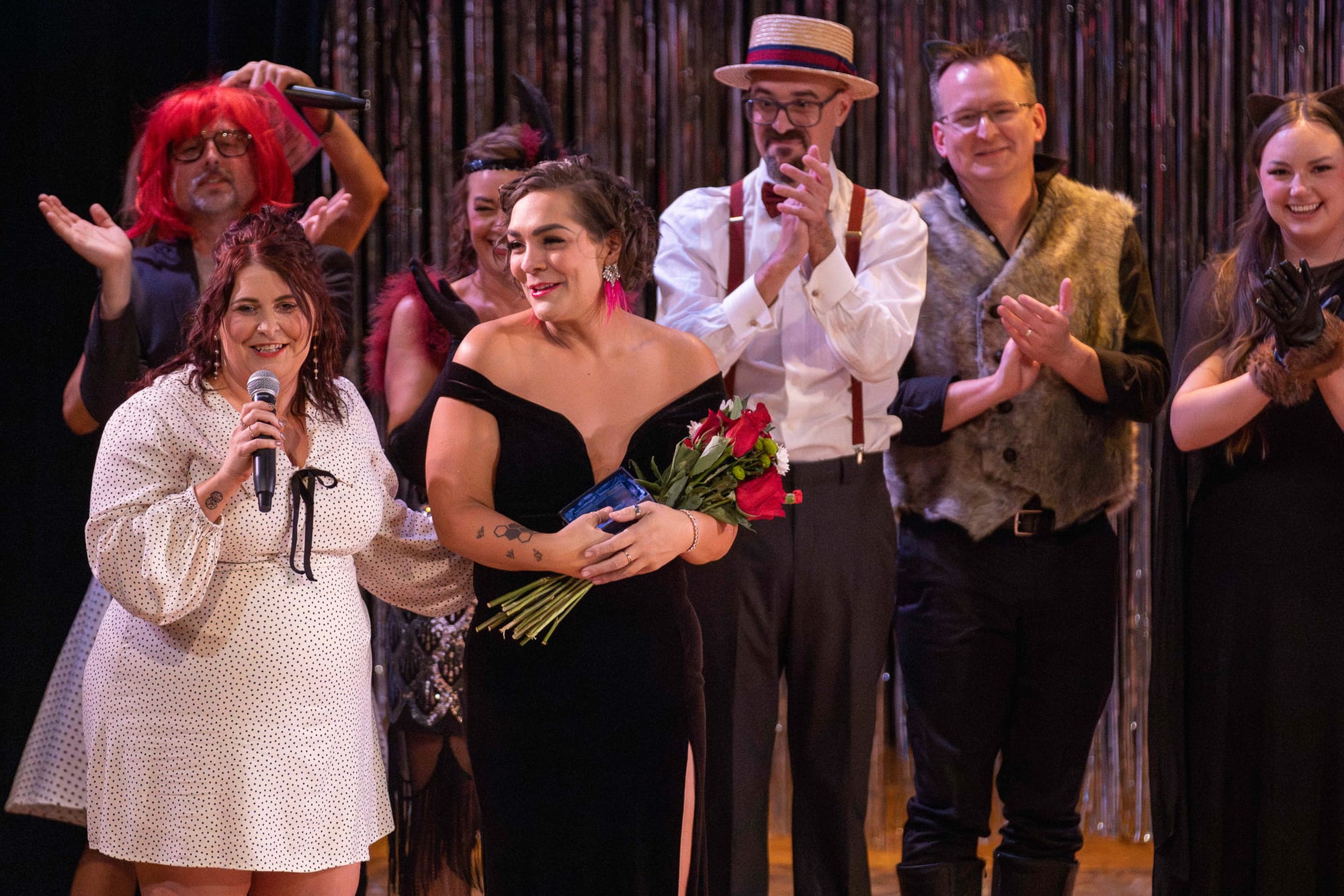 Saville Center Executive Director Heather Houle speaks as Abbie Graves holds flowers during the Dancing with Saville ceremony at the Seretean Center Hall.