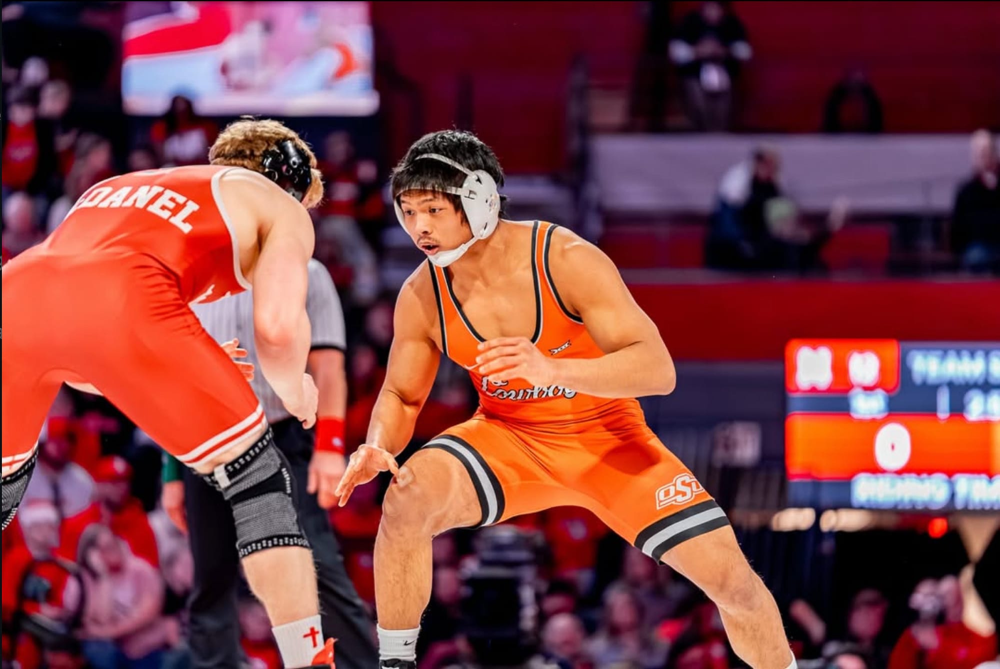 Cody Merrill in wrestling stance facing Nebraska opponent during dual at Lincoln