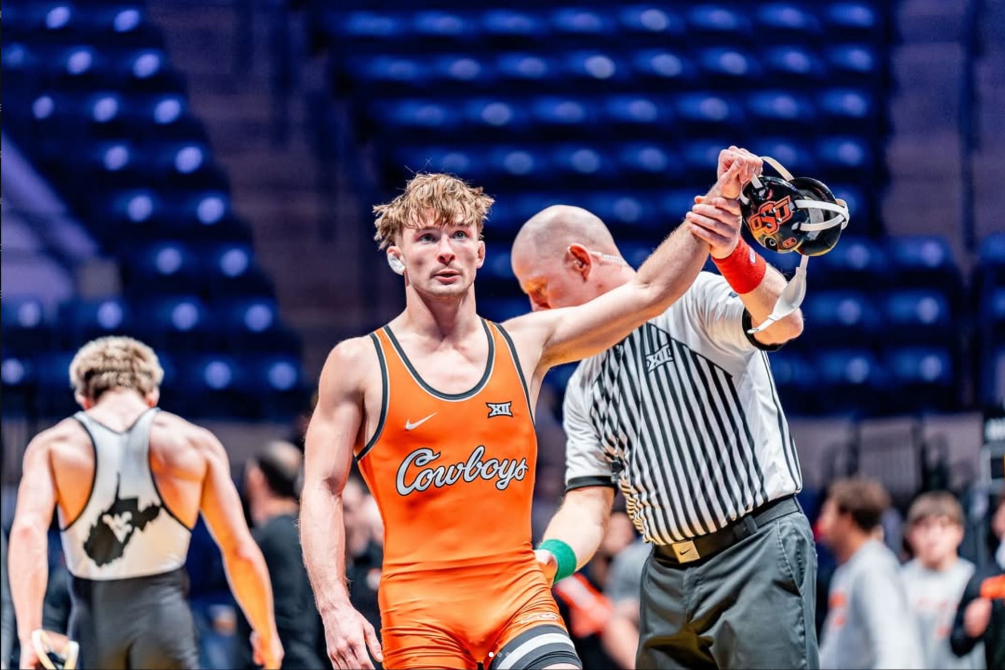 Oklahoma State wrestler Troy Spratley has his hand raised by a referee after defeating West Virginia's Jett Strickenberger 6-2 at 125 pounds.