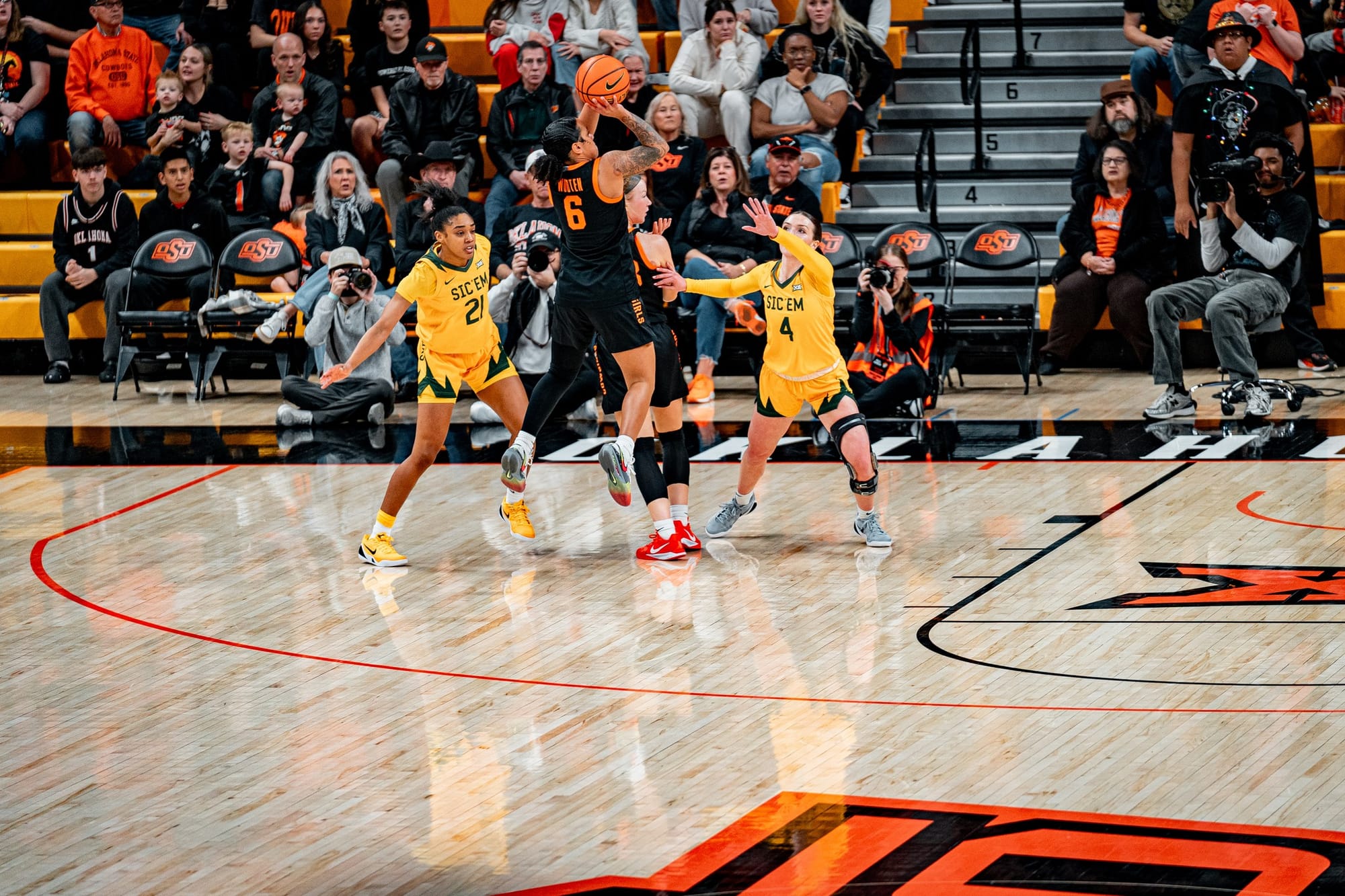 Oklahoma State guard Jadyn Wooten shoots the basketball over two Baylor defenders during the Cowgirls' 77-68 loss on New Year's Eve at Gallagher-Iba Arena in Stillwater, Oklahoma.