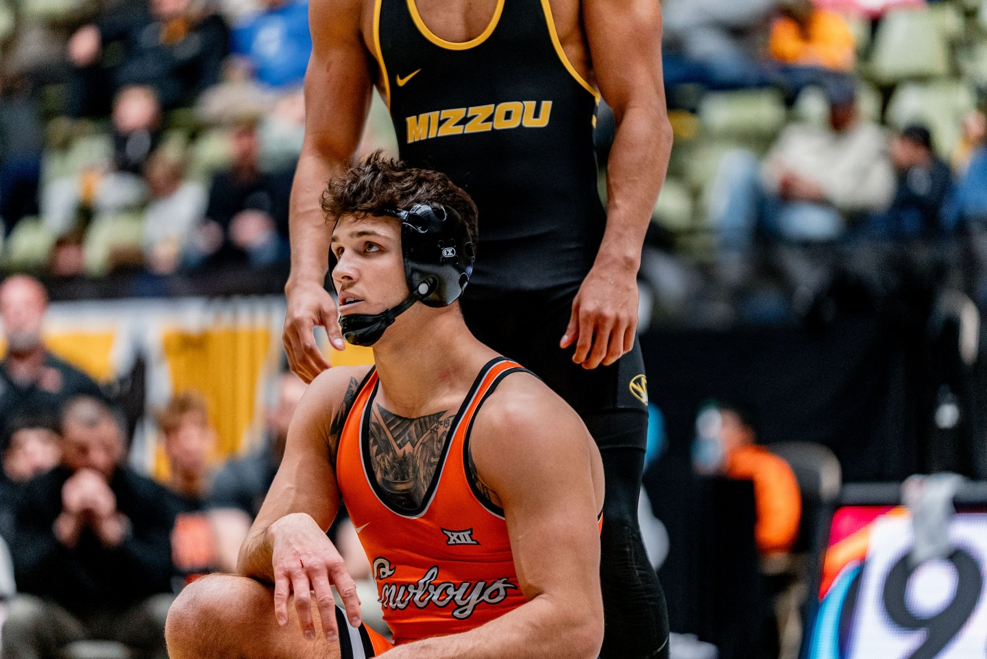 OSU wrestler Alex Facundo in orange Cowboys singlet competes against Missouri opponent in black Mizzou singlet at 174 pounds during Cowboys 33-3 dual meet victory at Hearnes Center Jan. 23, 2026
