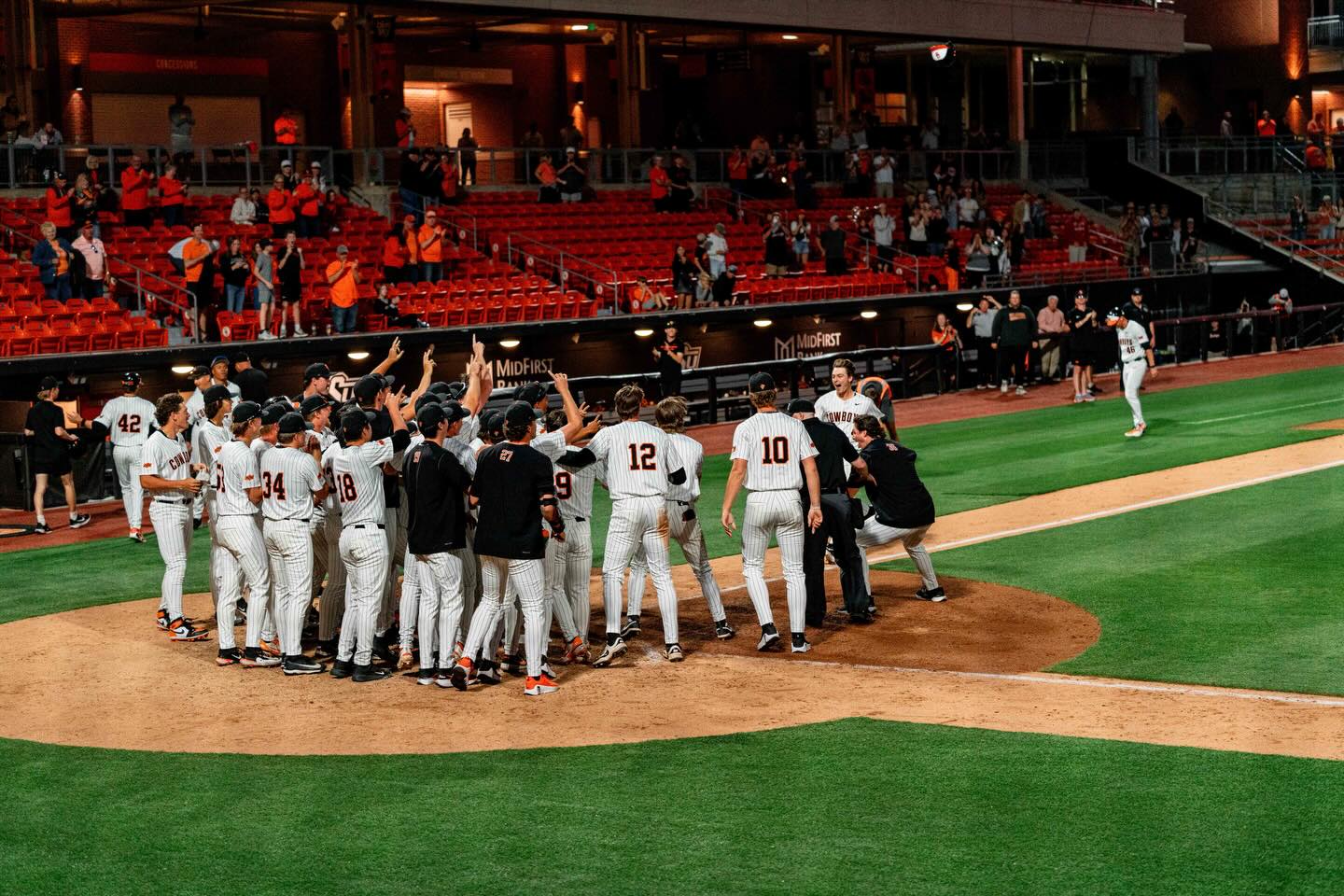 Oklahoma State players celebrate at home plate as Campbell Smithwick approaches after hitting a walk-off home run against South Dakota State at O'Brate Stadium on Wednesday night.