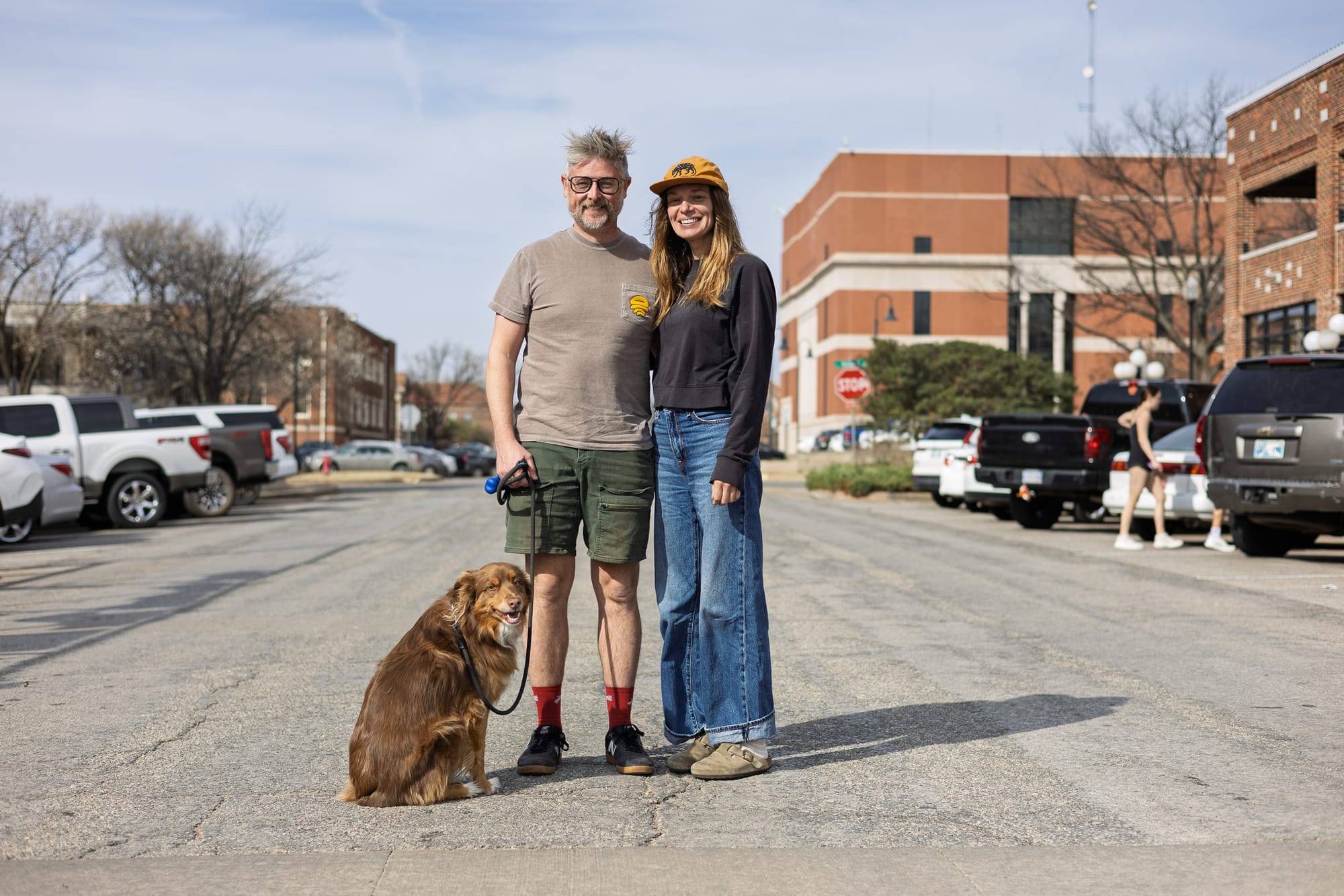Bobby and Crystal Wintle stand with their brown dog on West 7th Avenue in downtown Stillwater, with the Payne County Jail visible in the background.