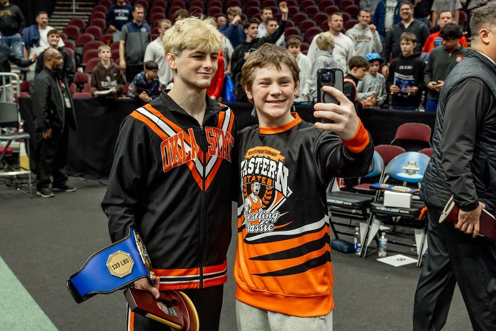 Jax Forrest poses for a selfie with a young fan on the arena floor after winning the 133-pound title at the 2026 NCAA Wrestling Championships in Cleveland.