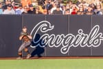 Oklahoma State outfielder Megan Delgadillo prepares to throw from the outfield during a home game against Texas at Cowgirl Stadium on April 23, 2025, with fans visible in the stands.