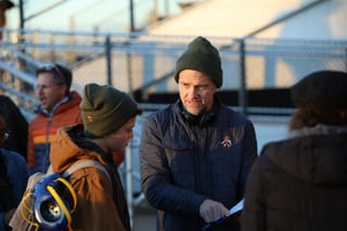 Sean Patrick Flanery and son Charlie Flanery on set during filming of "Thirteen Folds" at Stillwater High School, with bleachers visible in background