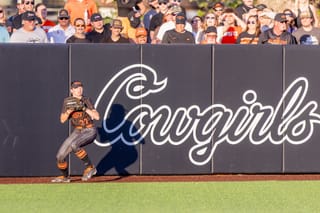 Oklahoma State outfielder Megan Delgadillo prepares to throw from the outfield during a home game against Texas at Cowgirl Stadium on April 23, 2025, with fans visible in the stands.