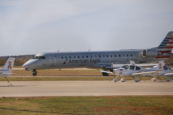American Eagle CRJ jet prepares for departure behind Oklahoma State University Flight Center trainer aircraft at Stillwater Regional Airport.