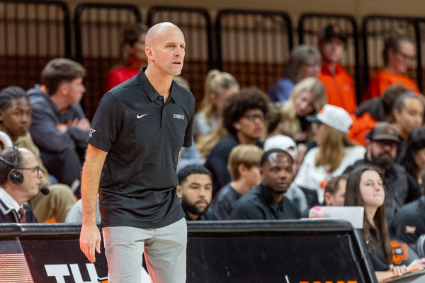 Oklahoma State head coach Steve Lutz stands on the sideline during a game at Gallagher-Iba Arena, wearing a black Cowboys polo shirt and khaki pants while coaching his team