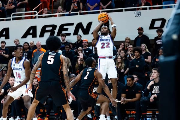 Kansas guard Darryn Peterson (22) rises for a jump shot over OSU defenders Vyctorious Miller (5) and Kanye Clary (7) during Kansas' 81-69 win at Gallagher-Iba Arena.