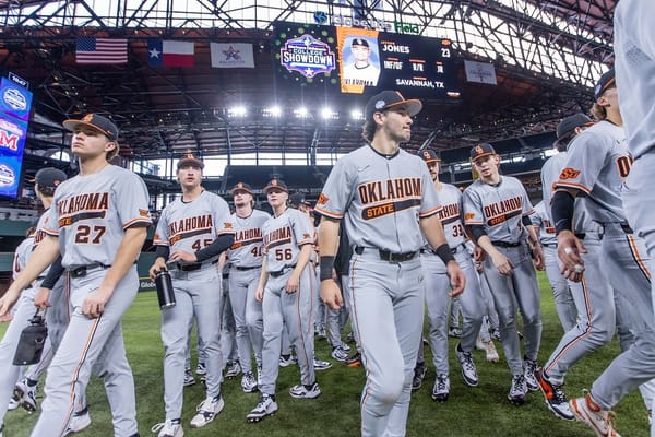 OSU baseball players in gray uniforms take the field at Globe Life Field during the Shriners Children's College Showdown. Cowboys open 2026 season at same Arlington tournament.