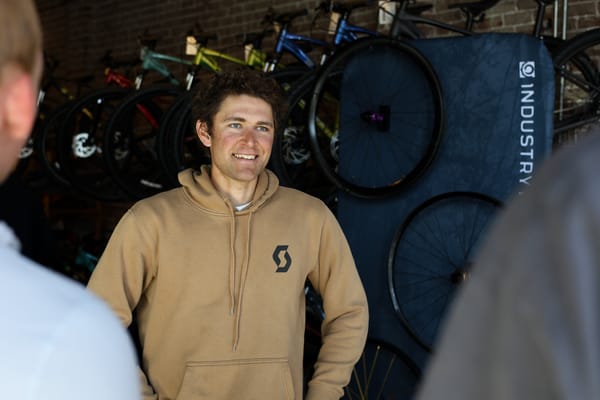 Cameron Jones at a pre-race meet-and-greet at District Bicycles in Stillwater, Oklahoma, March 12, 2026, wearing a Scott Cycling hoodie.